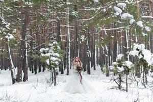 noiva e noivo em pulôveres de malha bege na floresta de neve. recém-casados está tocando testas. casamento de inverno. espaço de cópia foto