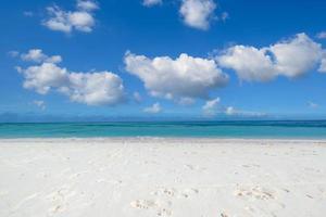 closeup de areia na praia e céu azul de verão. paisagem panorâmica da praia. praia tropical vazia e marinha. céu azul, areia fofa, calma, sol relaxante tranquilo, clima de verão. férias de viagem foto