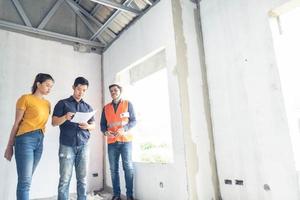 casal asiático verificando casa com capataz engenharia de inspeção de casa construção de casa inspeção de casa com vista e apontando construção para verificação de construção de casa no local de trabalho para construção 2021 foto