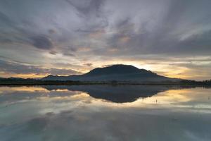 reflexo da colina de bukit mertajam no nascer do sol dramático dourado foto