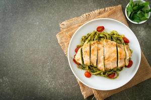 macarrão fettuccine espaguete ao molho pesto com frango grelhado foto