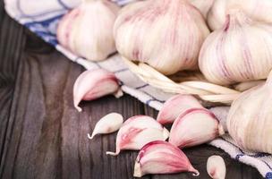 dentes de alho e bulbo de alho na toalha de cozinha foto