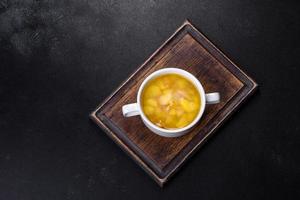 sopa de ervilha fresca em tigela sobre fundo preto. cozinhando em casa foto