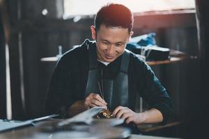 fabricantes de guitarra colocam cordas de violão depois de fazer violões acústicos na concept guitar shop, uma loja de guitarra artesanal. foto