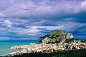 cidade velha à beira-mar, montanhas baixas ao fundo foto