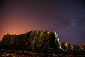 o céu estrelado acima das montanhas rochosas. foto