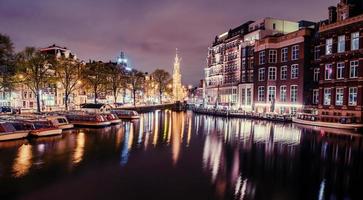 bela noite em amsterdã. iluminação de prédios foto