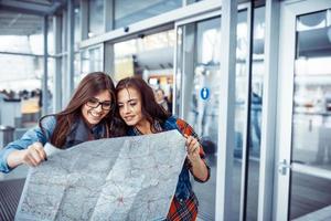 duas meninas bonitas estão estudando e olhando para o map.ar foto