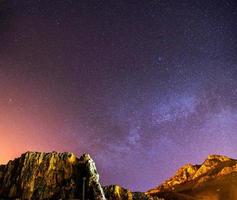 o céu estrelado acima das montanhas rochosas. foto