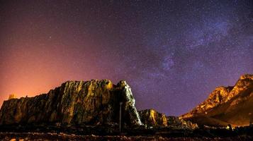 o céu estrelado acima das montanhas rochosas. foto