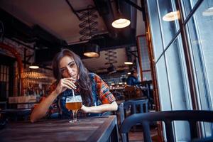 mulher de cerveja desfrutando de um rascunho fresco no café. processamento de arte foto