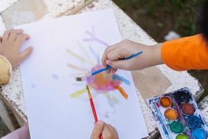 criança bonitinha pintando com tintas coloridas. menina asiática usando pincel desenho color.baby activity lifestyle concept foto