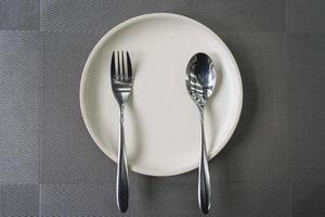 colher de prato vazio e garfo na mesa no restaurante. foto