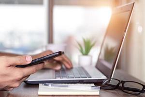 trabalho usando telefone celular digitando computador laptop de bate-papo móvel entre em contato conosco em locais de trabalho, planejando ideias investidores pesquisando na internet, ideias conectando pessoas. foto