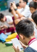 bangkok tailândia - 19 de abril de 2018 muitos alunos brincando com smartphone durante o tempo de freio na escola foto
