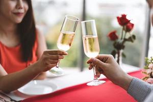 sorriso amante asiático casal homem e mulher mão segurar uma bebida de champanhe e torcer. foto