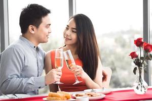 sorriso adulto amante asiático casal homem e mulher mão segura uma bebida de champanhe perto de uma janela. foto
