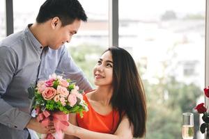 mão de casal de homem segura um presente romântico de buquê de flores para a namorada. foto