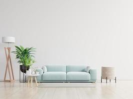 sala de estar vazia com sofá azul, plantas e mesa no fundo da parede branca vazia.