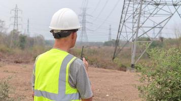 engenheiros elétricos estão inspecionando e mantendo grandes postes de alta tensão. foto