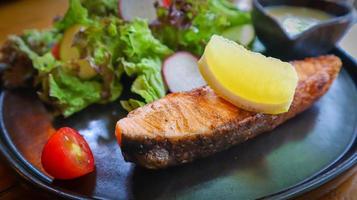 filé de salmão grelhado servido com salada verde mista e molho de salada de creme ceto. foto