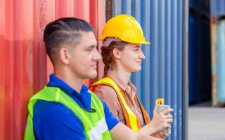 equipe alegre de operários em contêineres de carga, conceito de trabalho de felicidade foto