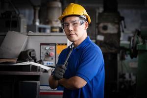 engenharia da indústria vestindo controle uniforme de segurança operando máquina de moagem de torno controlada por computador trabalhando na fábrica da indústria. foto