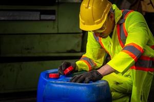 indústria de engenharia usando uniforme de segurança, luvas pretas, máscara de gás se sente sufocada ao verificar o tanque químico no trabalho da fábrica da indústria. foto