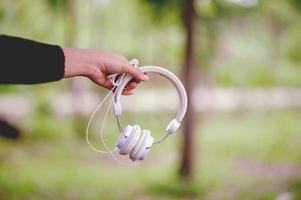 fones de ouvido de mão e brancos, dispositivos para ouvir música diariamente música e conceitos de música foto