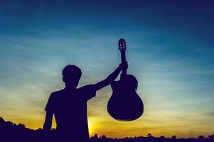 silhueta de um guitarrista nas sombras à luz do sol, conceito de silhueta. foto