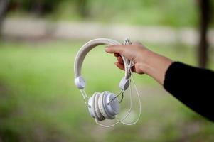 fones de ouvido de mão e brancos, dispositivos para ouvir música diariamente música e conceitos de música foto