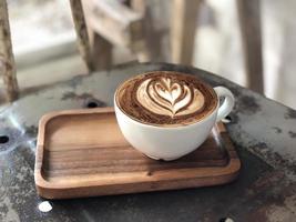 latte art na xícara de café na mesa de madeira foto