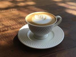 xícara de café quente na mesa de madeira foto