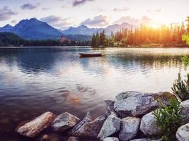 o nascer do sol sobre um lago no parque high tatras. shtrbske pleso, foto