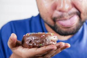 jovem comendo rosquinha, foco seletivo foto