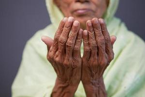 close-up da mão de uma mulher idosa rezando no ramadã foto