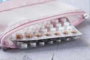 pílulas anticoncepcionais em fundo de madeira, close-up foto