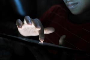 mão de homem usando tablet digital em fundo preto foto