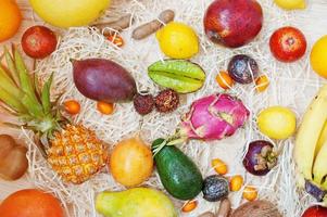 frutas exóticas em fundo de madeira. alimentação saudável dieta alimentar. pitaia, carambola, mamão, abacaxi, manga, maracujá, tamarindo e outros. foto