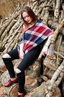 garota jovem hippie usar cobertor contra tocos de madeira na madeira. foto