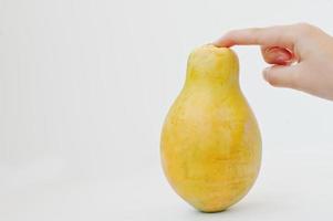 mamão de frutas exóticas ou mamão isolado no fundo branco com mão humana. alimentação saudável dieta alimentar. foto