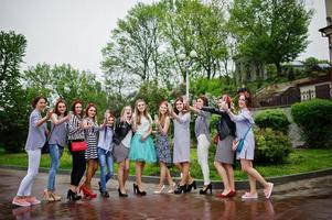 onze damas de honra atraentes com linda noiva comemorando despedida de solteira com champanhe no parque. foto
