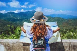 mulher asiática viajar relaxe no feriado. stand verão campo de montanha de toque natural. ver mapa viagens explorar. Na Tailândia foto