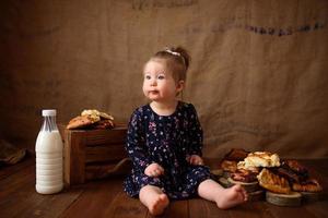 menina na cozinha come bolos doces. foto