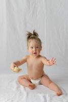 menina de dez meses está brincando com um brinquedo foto