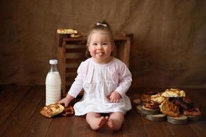 menina na cozinha come bolos doces. foto