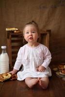 menina na cozinha come bolos doces. foto