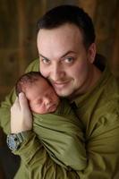 pai segura com amor seu filho recém-nascido. foto