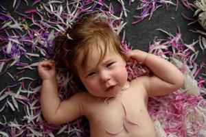 retrato de uma doce menina com uma coroa de flores na cabeça dentro de casa foto