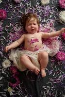 retrato de uma doce menina com uma coroa de flores na cabeça dentro de casa foto